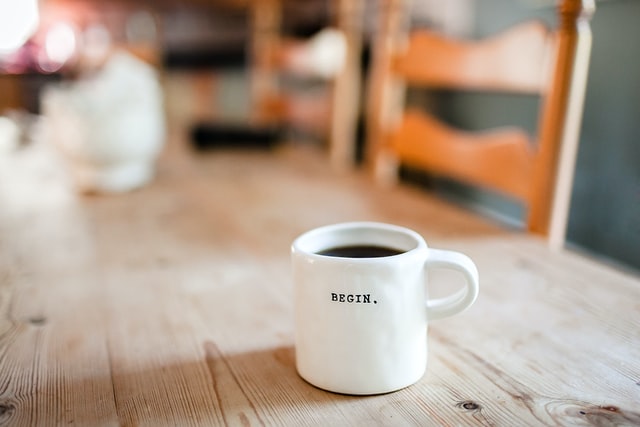 A cup of coffee with the word begin printed on it